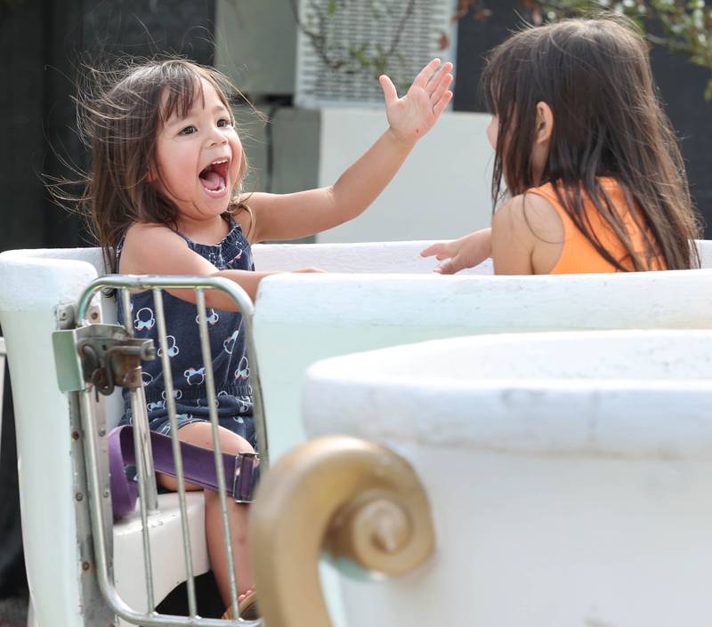 Verity Onate, (left) 3, and her sister Evee, 5, from DeKalb ride the teacups at the carnival during Corn Fest Friday, Aug. 25, 2023, in downtown DeKalb.