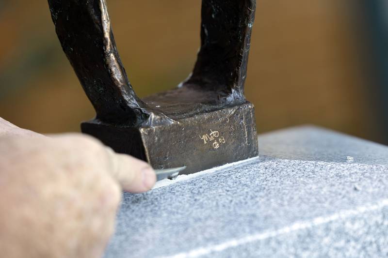 Dan Johns cleans up the joint Monday, Oct. 20, 2025, while placing the new sculpture at the library in Franklin Grove.