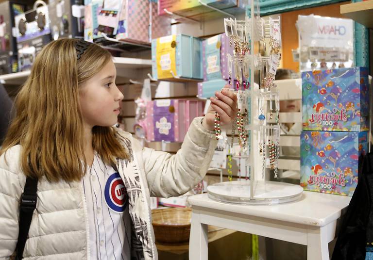 Madi Dickman, 8, of Crystal Lake shops for Christmas presents for her cousins Monday, Dec. 19, 2022, at Marvin's Toy Store in Crystal Lake. This year, Marvin's most popular items are  construction kits and screen-less-technology toys, including the Toniebox, that reads stories to children.