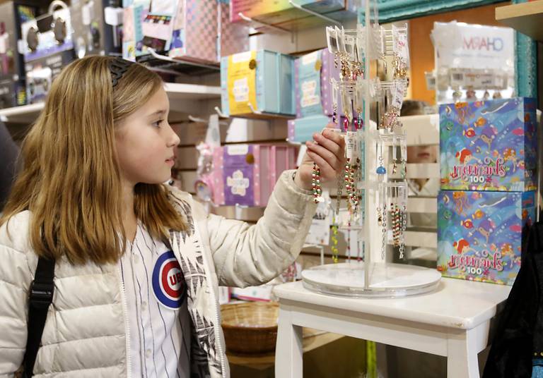 Madi Dickman, 8, of Crystal Lake shops for Christmas presents for her cousins Monday, Dec. 19, 2022, at Marvin's Toy Store in Crystal Lake. This year, Marvin's most popular items are  construction kits and screen-less-technology toys, including the Toniebox, that reads stories to children.