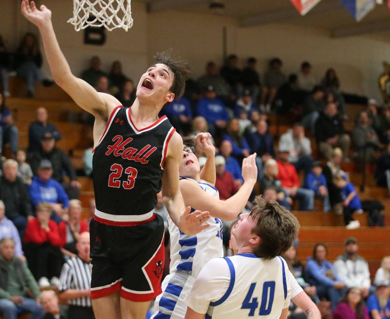 Hall's Braden Curran scores over Princeton's Sean Mayard and Wyat Koning on Friday, Jan. 26, 2024 at Princeton High School.