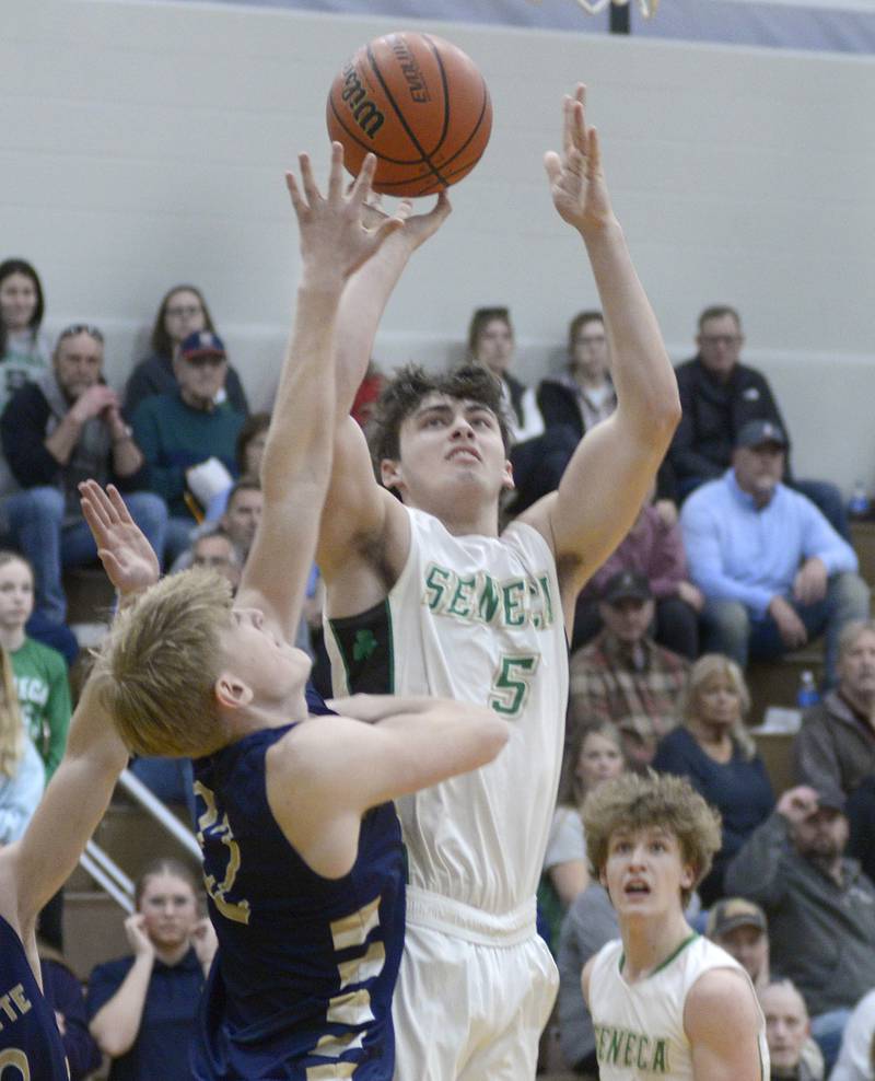 Seneca’s Kysen Klinker gets this shot away from the block attempt by Marquette’s Henry McGrath Tuesday during the 2nd period at Seneca.