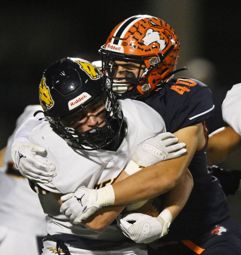 Neuqua Valley’s Andrew Barkley, front, gets tackled by Naperville North’s Benjamin Mittenthal during a football game played on Friday, Oct. 11, 2024 in Naperville.