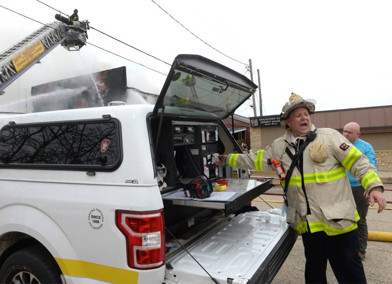 Mt. Morris Fire Chief Rob Hough directs crews from his command vehicle at a structure fire at the corner of Main Street and Wesley Avenue in downtown Mt. Morris on Tuesday, April 16, 2024.