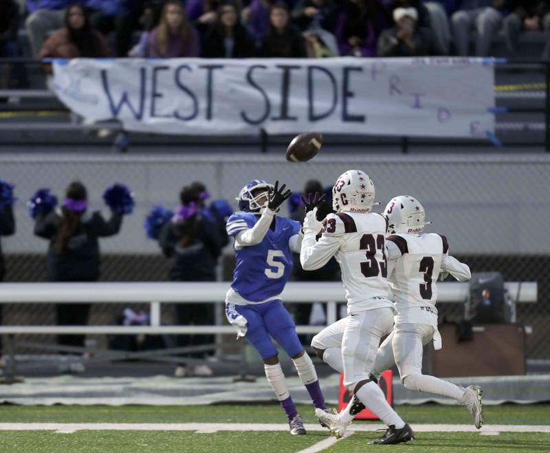 Larkin's Damani Cannon (5) looks to haul in a long pass over Elgin’s Matthew Lawson (33) and Yandel Garcia (3) during the annual crosstown rival game at Memorial Field  Friday October 14, 2022 in Elgin.