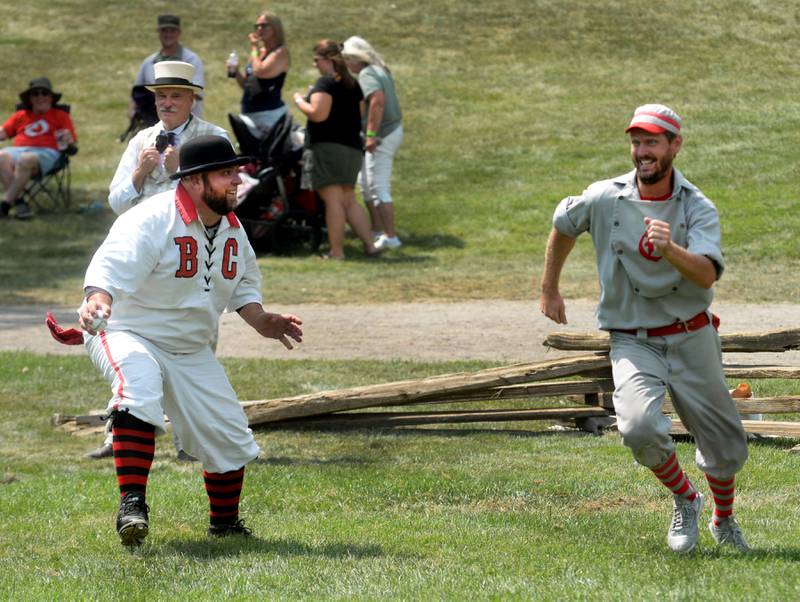 Oregon Ganymede Brett Rogers (right) and the catcher for the Bay City Independent smile as they play a game of cat and mouse as Rogers tries to avoid the tag at home during the World Tournament of Historic Base Ball held at the Henry Ford Museum's Greenfield Village on Saturday, Aug. 9, 2025.
