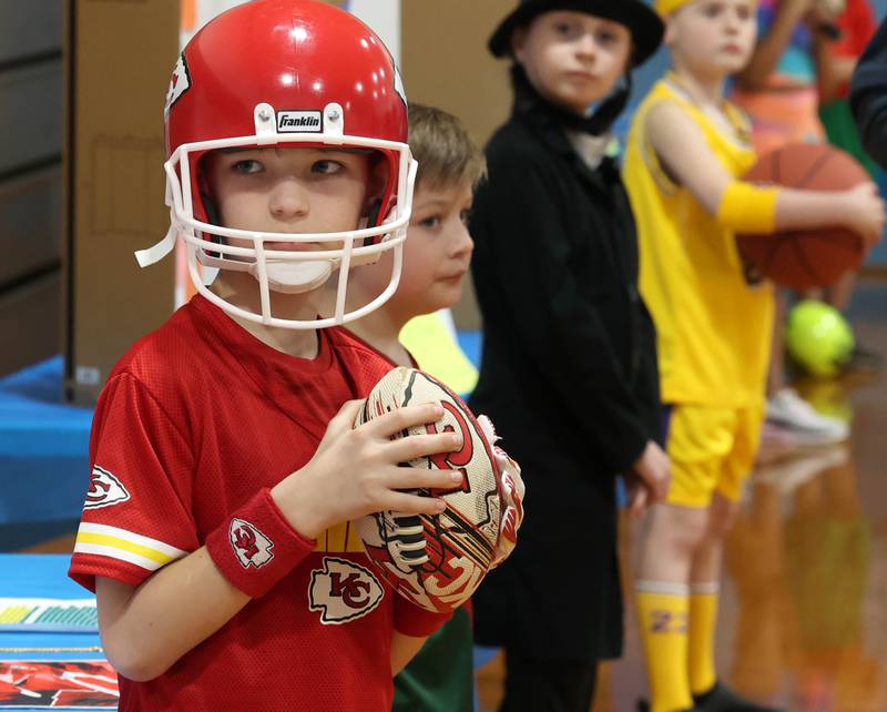 Third grader Austen Yaggie, (left) playing Patrick Mahomes, waits for someone to press the button to activate his speech during the Hinckley Big Rock Elementary School Wax Museum Thursday, March 13, 2025, at the school in Hinckley.