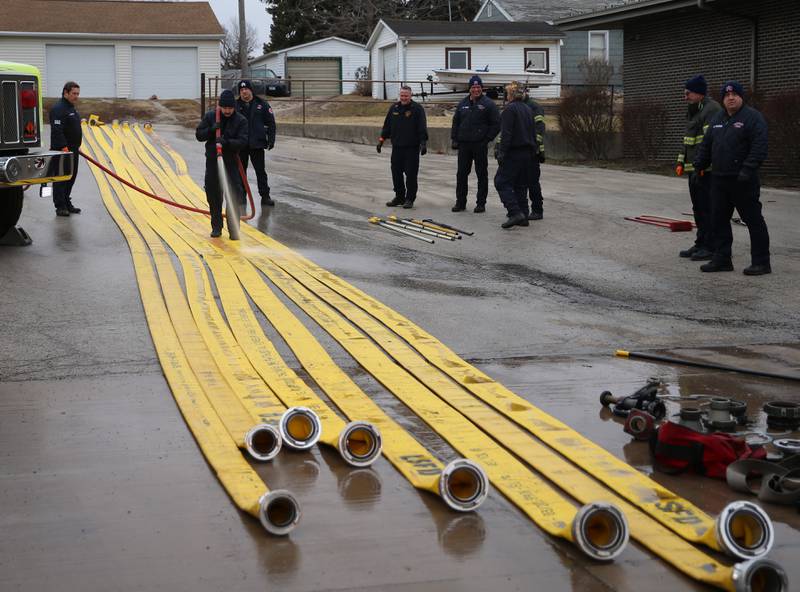Firefighters from Aurora, Batavia, St. Charles and Big Rock fire departments wash down hoses used in the Carus Chemical fire on Thursday, Jan. 12, 2023 at the La Salle Fire Station