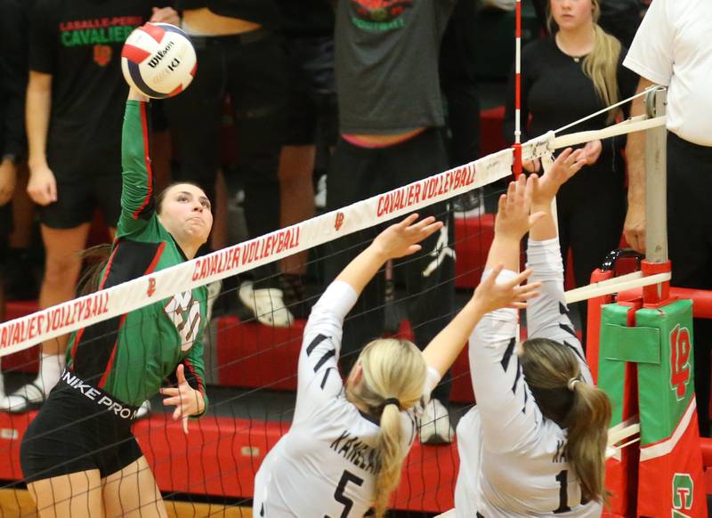 L-P's Anna Riva spikes the ball past Kaneland's Kayli Loonam and teammate Leah Shirley in AJ Sellett Gymnasium on Thursday, Oct. 24, 2024 at L-P High School.