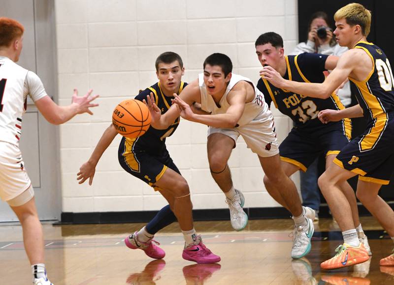 Forreston's Joseph Kobler (0) passes the ball to a teammate as Polo's Mercer Mumford, Korbin Cavanaugh, and JT Stephenson defend on Saturday, Dec. 13, 2025 at the 64th Annual Forreston Holiday Basketball Tournament held at Forreston High School.