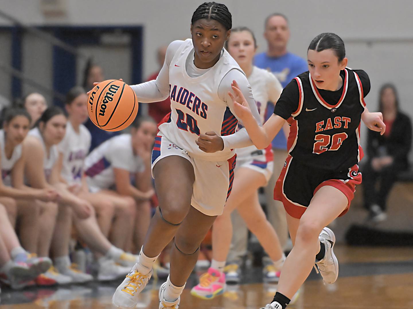 Glenbard South’s Brooklynn Moore brings the ball up court as Glenbard East’s Olivia Nee runs with her in a girls basketball game in Glen Ellyn on Friday, Feb. 7, 2024.