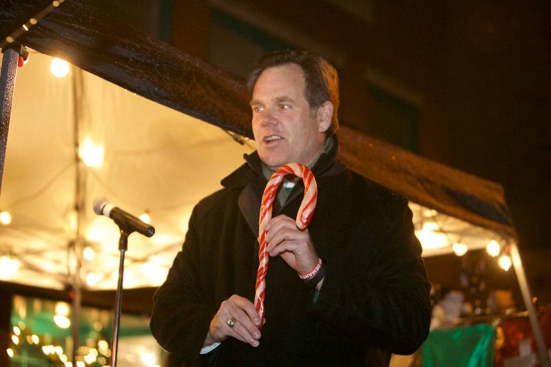 Geneva Mayor Kevin Burns holds up the first candy cane at the Geneva Christmas Walk on Friday, Dec.1 2023 in Geneva.