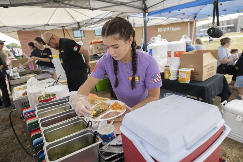 Dishing up the goods at Carlos’ Taco booth Saturday, Sept. 13, 2025, Kaya Imel works on a customer's order during Taste of Fiesta in Rock Falls.