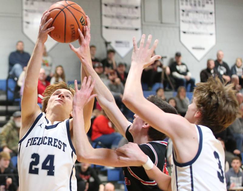 Fieldcrest's Dallis Cook grabs a rebound over Woodland's Nick Plesko on Tuesday, Dec. 19, 2023 at Fieldcrest High School.