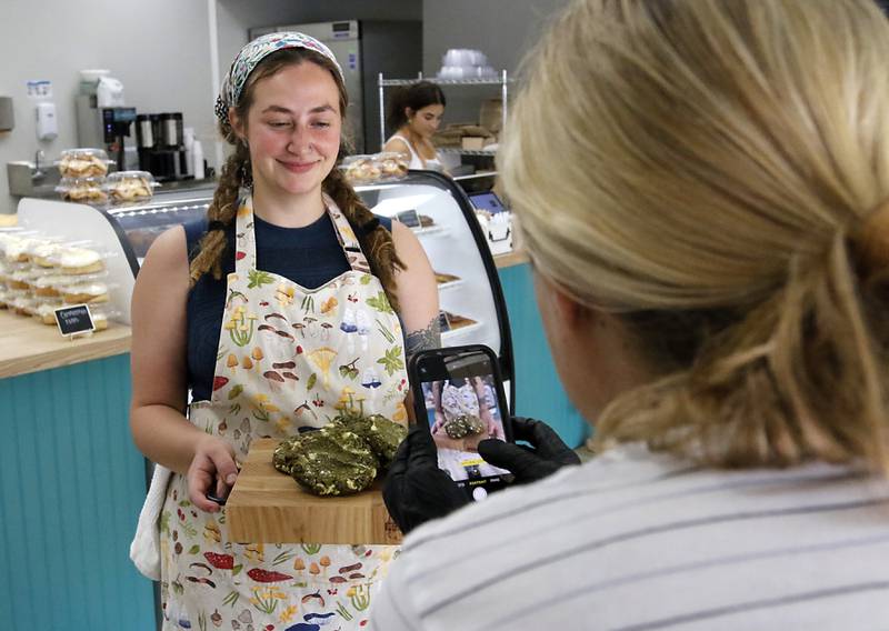 Rachel Skubiszewski photographs Sara Bartyzel as she holds a tray of white chocolate matcha for their Instagram page on Friday, June 27, 2025, at the recently opened Black Market Bakery in downtown Crystal Lake.