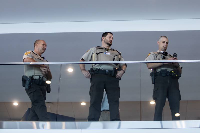 Members of law enforcement observe the opening of the 'Portrait of a Soldier' exhibit from the second floor at the Will County Courthouse in Joliet, Illinois on Sept. 11, 2025.