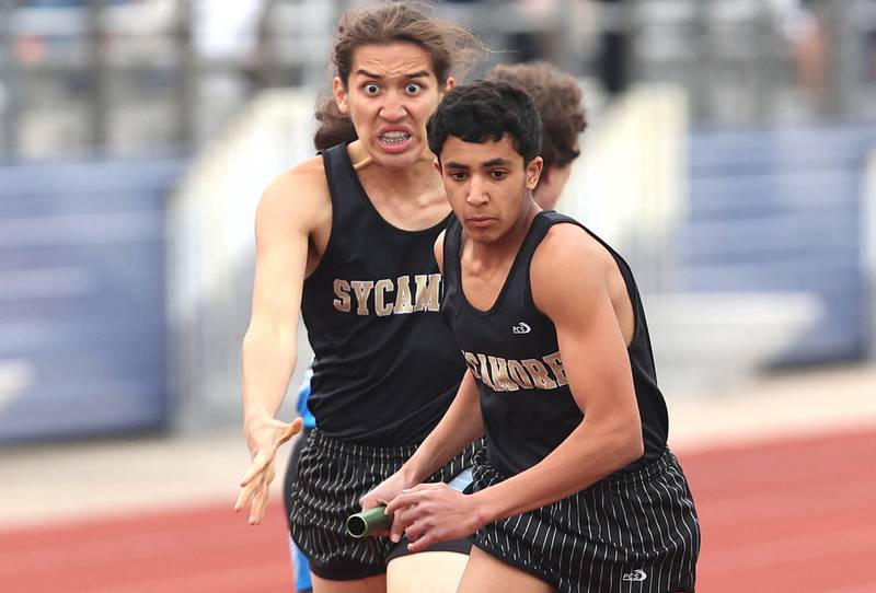 Sycamore's Luis Garcia hands the baton off to Naif Al Harby during the 4x800 meter relay Wednesday, May 18, 2022, at the Class 2A boys track sectional at Rochelle High School.