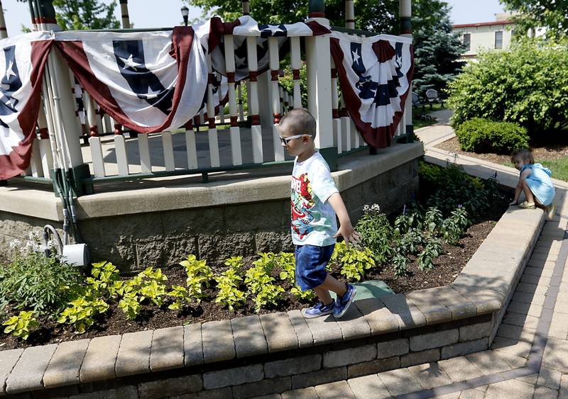 Jackson Graff, 4, and his sister, Madison, 2, look for places to hide on Wednesday, June 7, 2023, while playing hide-and-seek with their father, Ryan, around the gazebo in Huntley.