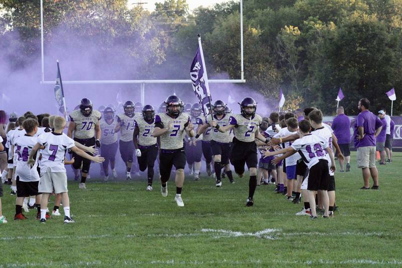 Members of the Dixon High School football team race onto the football field before a game on Sept. 9. The field's deteriorating condition was one topic of conversation during a working session of the board of education.