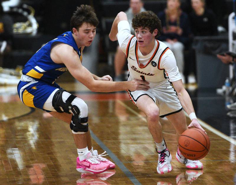 St. Charles East's Jake Greenspan (1) drives past Wheaton North's Caleb Schauer during Wednesday’s boys basketball game in St. Charles.
