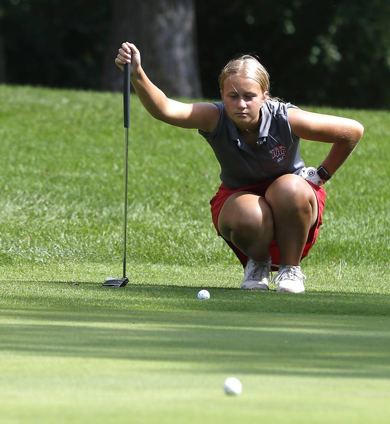 Hunlley’s Aubrey Dingbaum lines up a putt on the first green during the Fox Valley Conference Girls Golf Tournament Wednesday, Sept. 21, 2022, at Crystal Woods Golf Club in Woodstock.