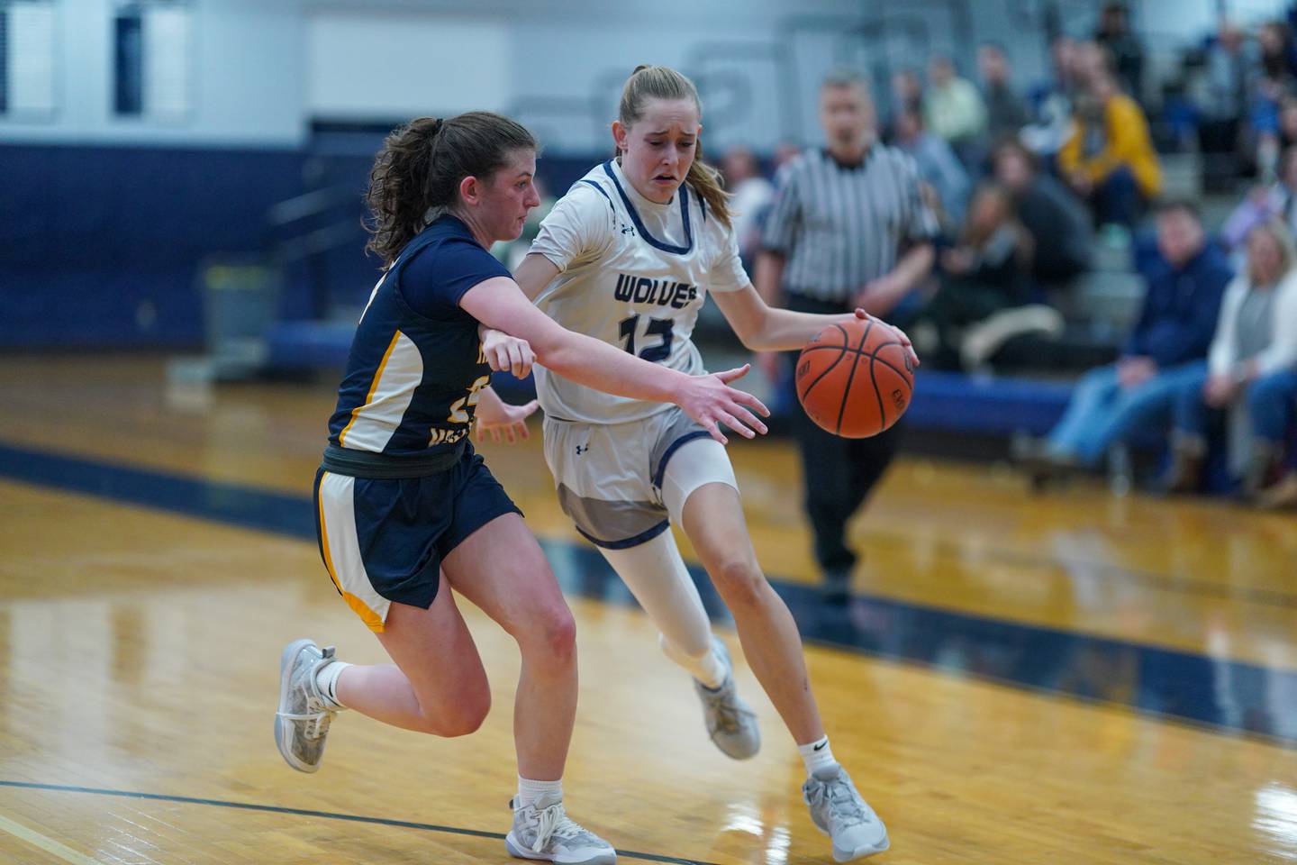 Oswego East's Nicole Warbinski (12) drives to the basket against Neuqua Valley's Nalia Clifford (24) during a basketball game at Oswego East High School in Oswego on Saturday, Jan 6, 2024.