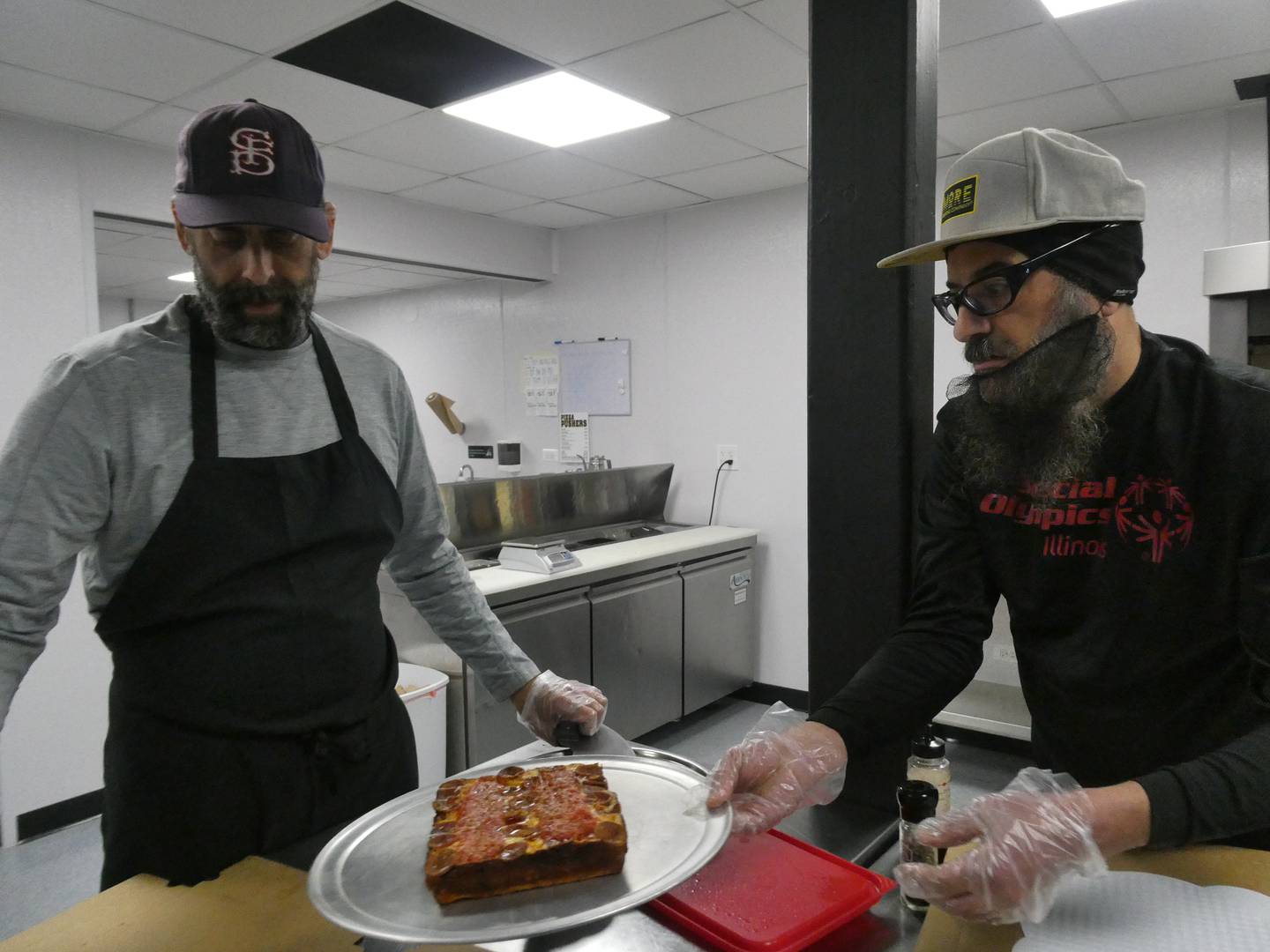Co-owners Harry Canelos and Jamie Trakas present a Detroit-style pepperoni pizza inside the kitchen at Pizza Pushers, a new joint in Algonquin that specializes in Motor City offerings.