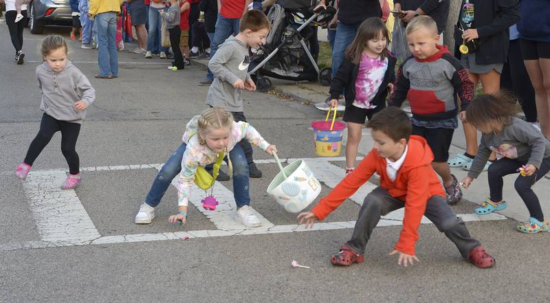 Children scramble for candy treats thrown their way during  the Homecoming Parade route on La Salle St Wednesday evening in Ottawa.