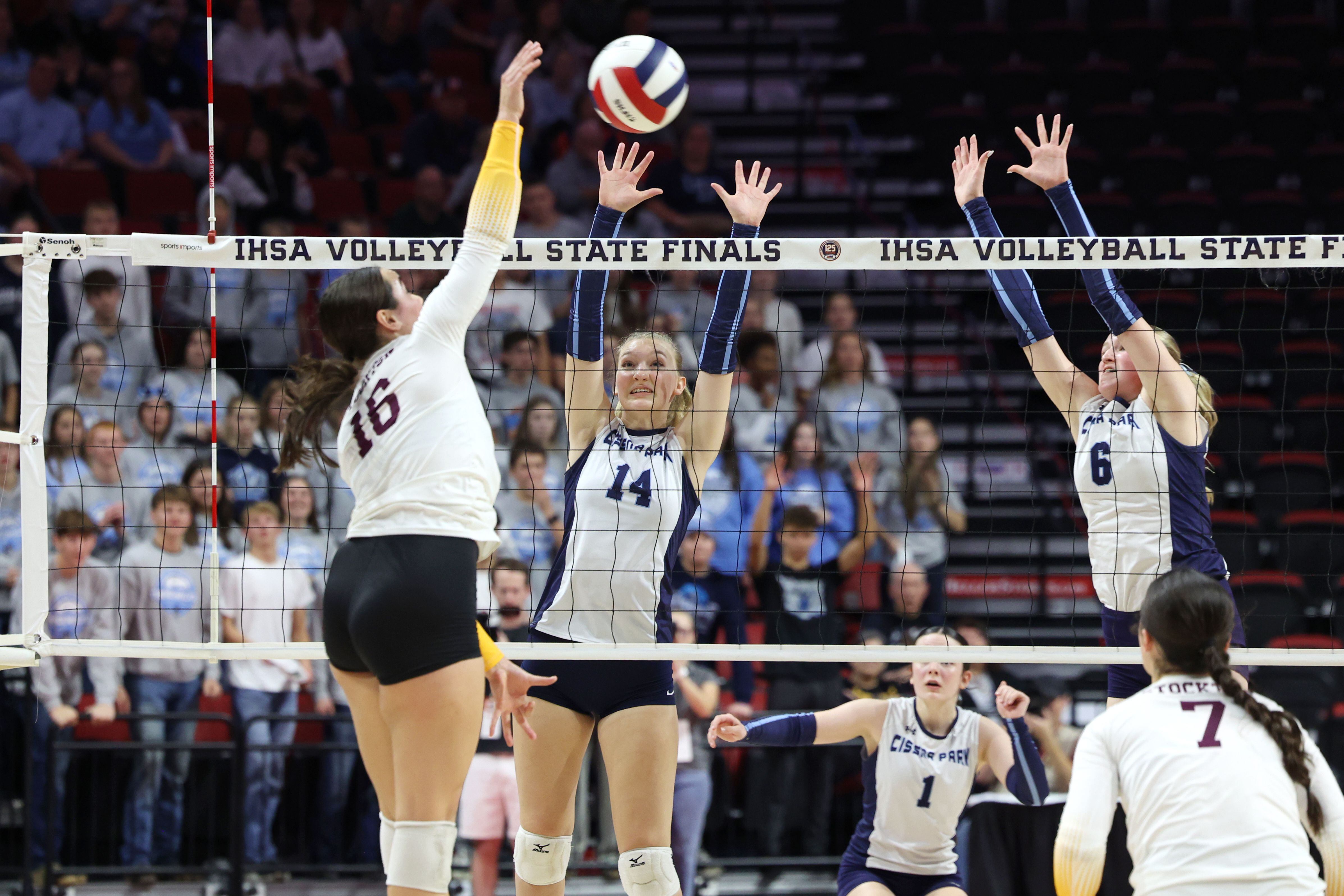 Cissna Park's Annika Stadeli, center, and Marina Day jump to block a hit during the Timberwolves' victory in two sets, 25-11, 25-14, over Stockton in the IHSA Class 1A State championship on Saturday, Nov. 15, 2025.