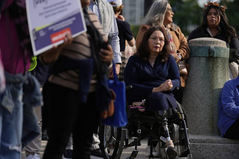 Sen. Tammy Duckworth, D-Ill., watches as people gather during Illinois Coalition for Immigrant & Refugee Rights' "Chicago Says No Trump No Troops" protest Saturday, Sept. 6, 2025, in Chicago. (AP Photo/Carolyn Kaster)