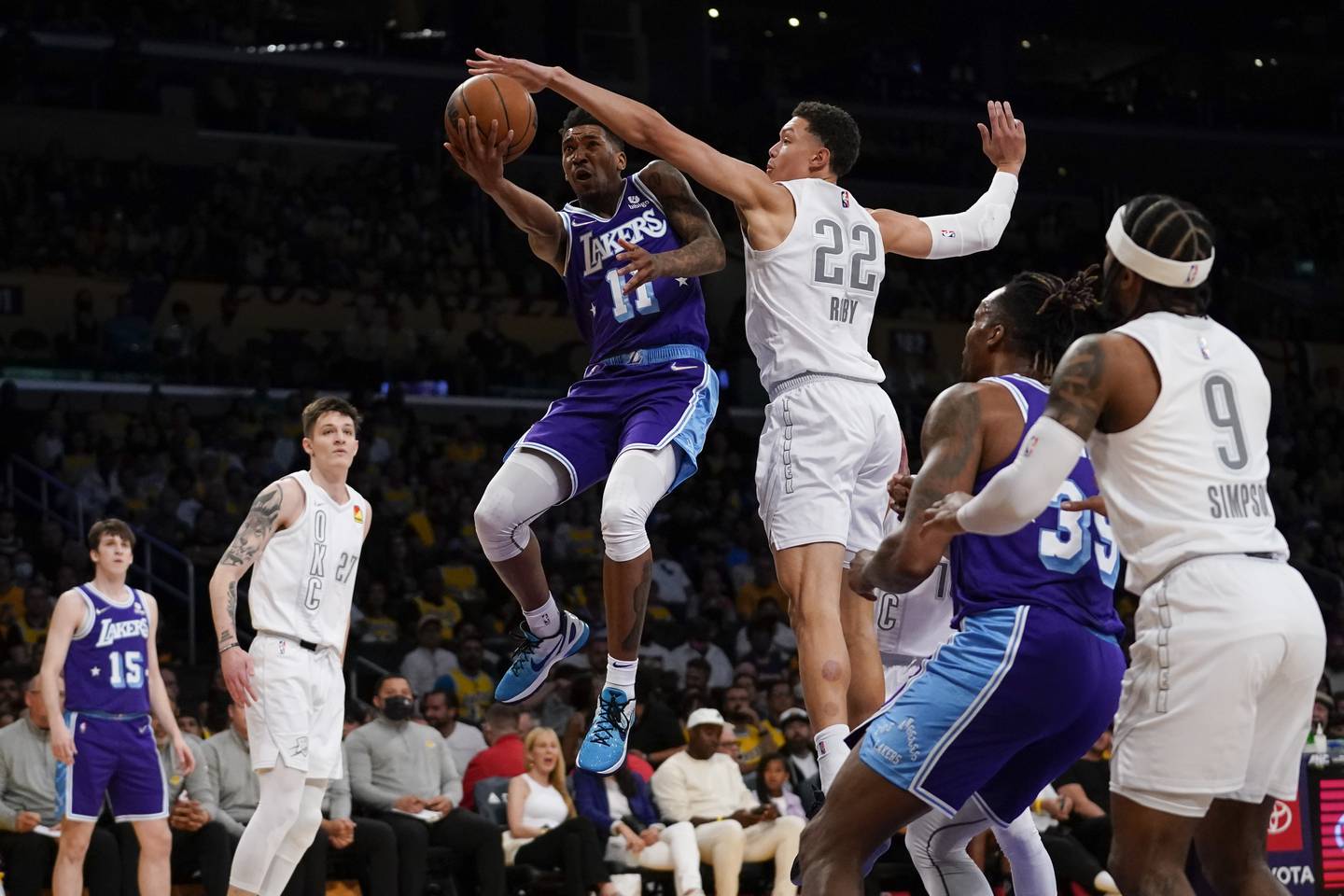 Los Angeles Lakers guard Malik Monk (11) shoots against Oklahoma City Thunder forward Isaiah Roby (22) during the first half Friday, April 8, 2022 in Los Angeles, Friday, April 8, 2022. (AP Photo/Ashley Landis)