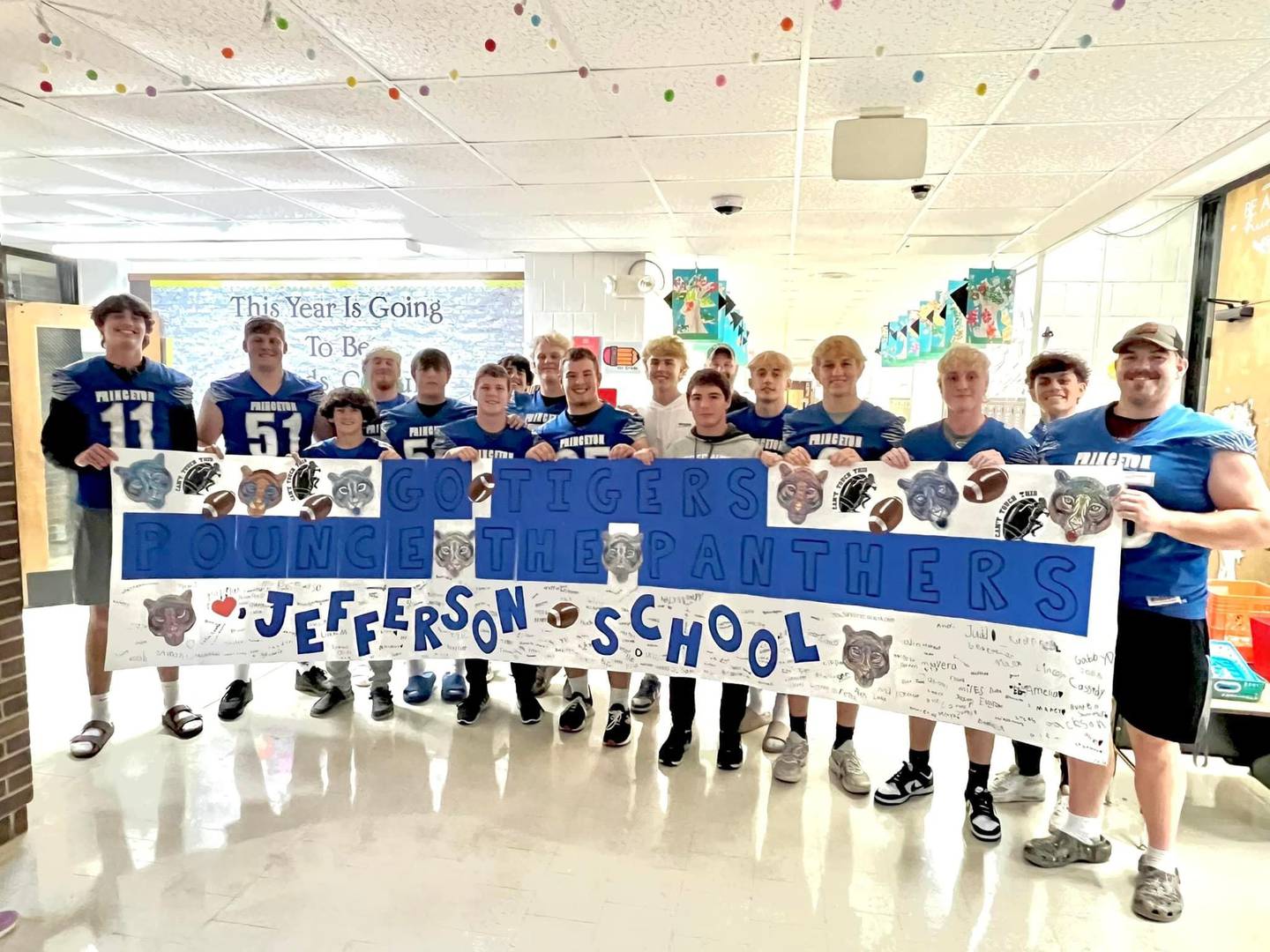 The students of Jefferson School presented a banner to the football players who read to them at school Wednesday.