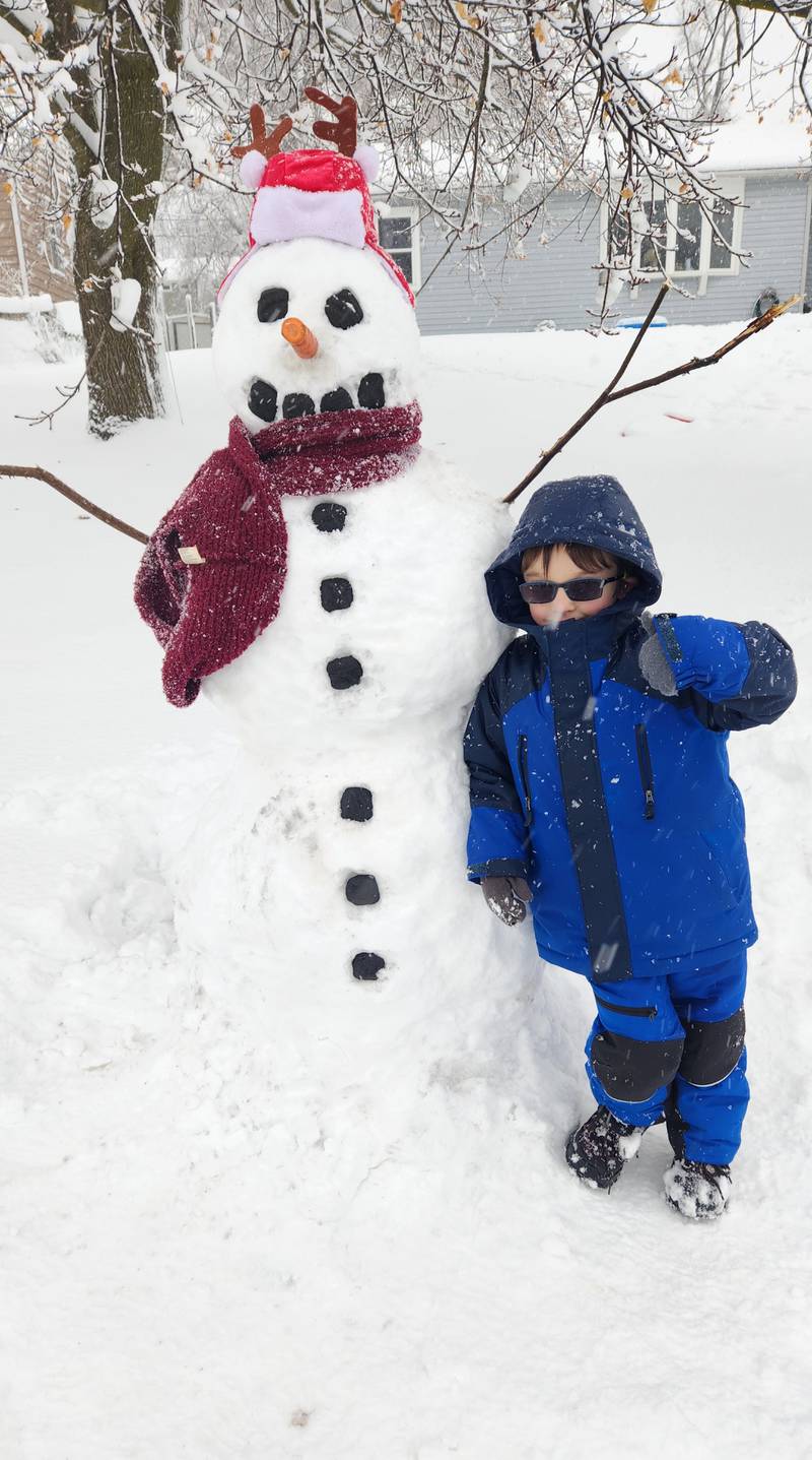 Wonder Lake resident John Cass took advantage of Friday's snow storm by building a snowman and sledding with his dad, Matt Cass.