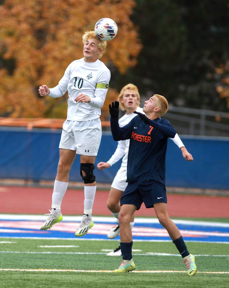 Crystal Lake South’s Nolan Getzinger heads the ball away from Rochester’s Jack Reid during the Class 2A state semifinal match at Hoffman Estates High School on Friday, Nov. 3, 2023.
