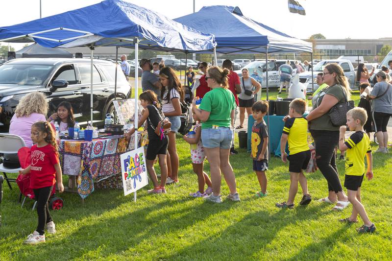 Children stand in line to have their face painted at the Joliet Police Department's National Night Out event Tuesday, Aug 5, 2025  in Joliet.