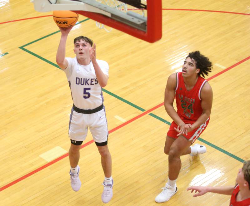 Dixon's Brady Feit runs in the lane to score on a layup over L-P's Marion Persich during the Class 3A Regional semifinal game on Wednesday, Feb. 26, 2025 in Sellett Gymnasium at L-P High School.