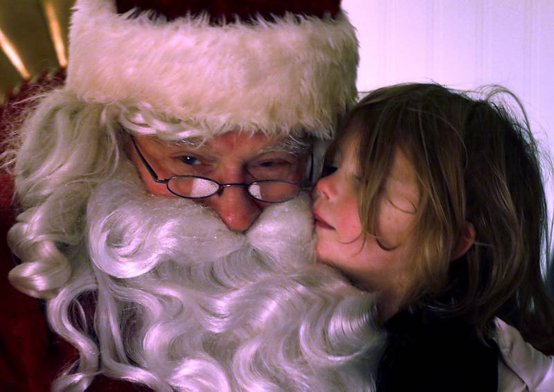 Evie Benstein, 3, hugs Santa Claus during Crystal Lake's Luminary Nights on Thursday, Dec. 19, 2024, in downtown Crystal Lake. The snowy night featured sidewalks lite luminaries, holiday shopping and a visit to the Santa House.