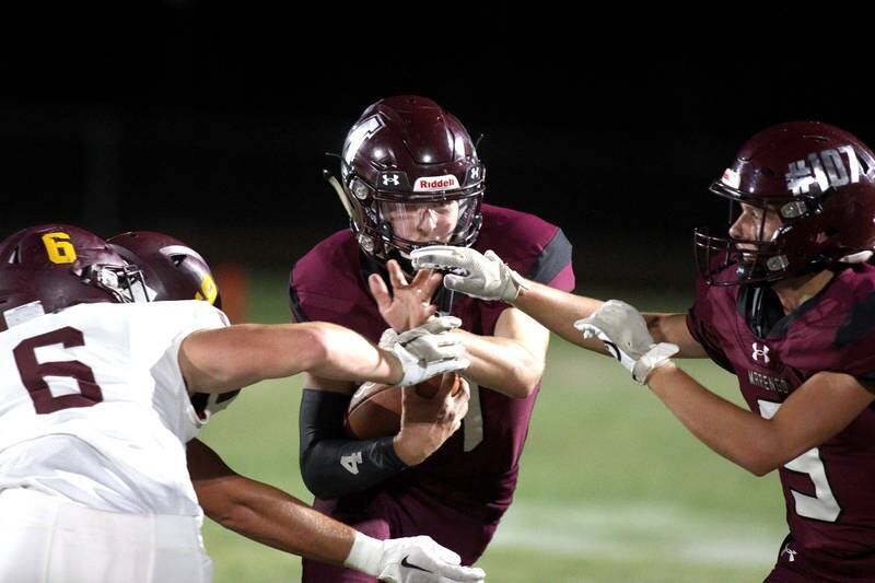 Marengo’s Mason Lampe, center, looks for running room as teammate Drew Johnson, right, prepares to block against Richmond-Burton in varsity football at Rod Poppe Field in Marengo Thursday night.