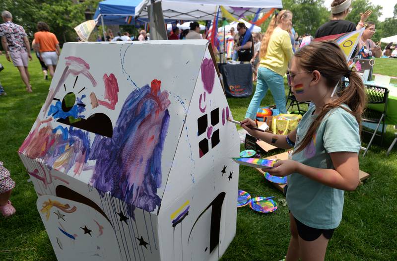 Chloe Svec of Downers Grove adds more color to the community home during the Downers Grove Pride Fest Saturday June 7, 2025.