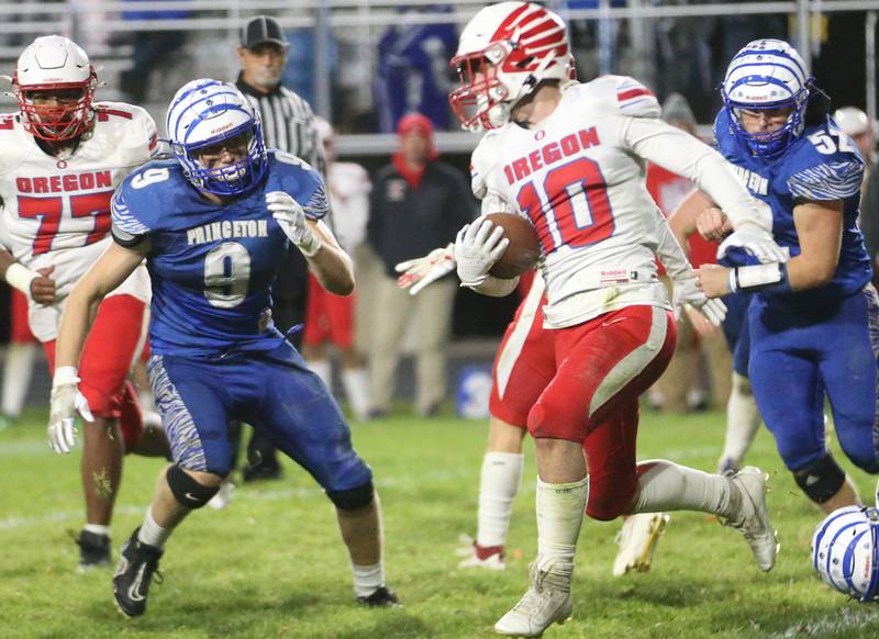 Oregon's Keaton Salsbury runs the ball past Princeton's Arthur Burden and Ian Morris during the Class 3A playoff game on Friday, Nov. 1, 2024 at Princeton High School.