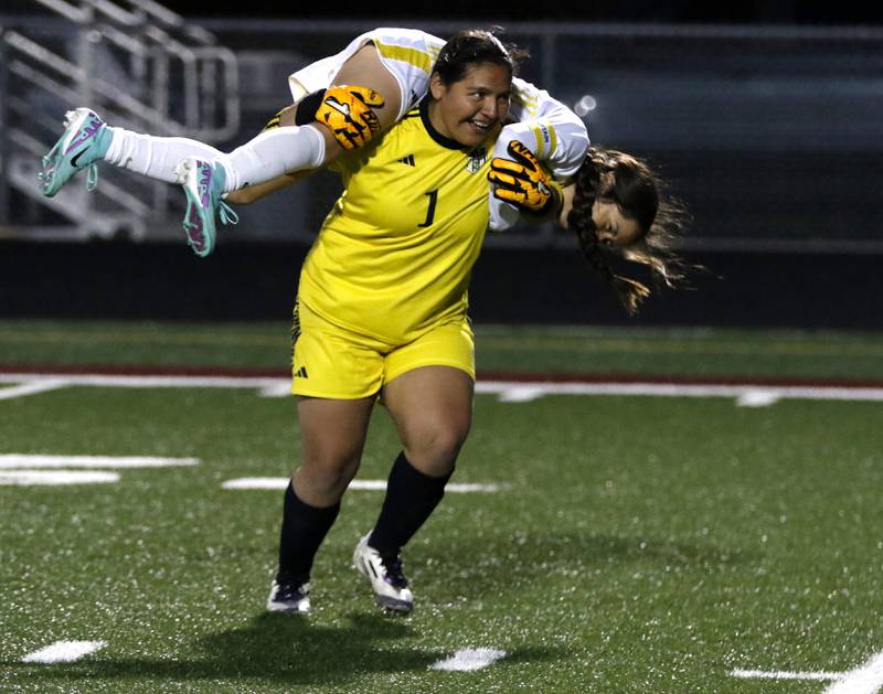 Harvard's Jarithsie Mercado carries her teammate, Estefany Castro, as they celebrate Harvard’s 7-6 penalty kick shootout win in the Kishwaukee River Conference Girls Soccer Tournament Championship Match over Richmond-Burton on Wednesday, May 7, 2025, at HRichmond-Burton High School in Richmond.
