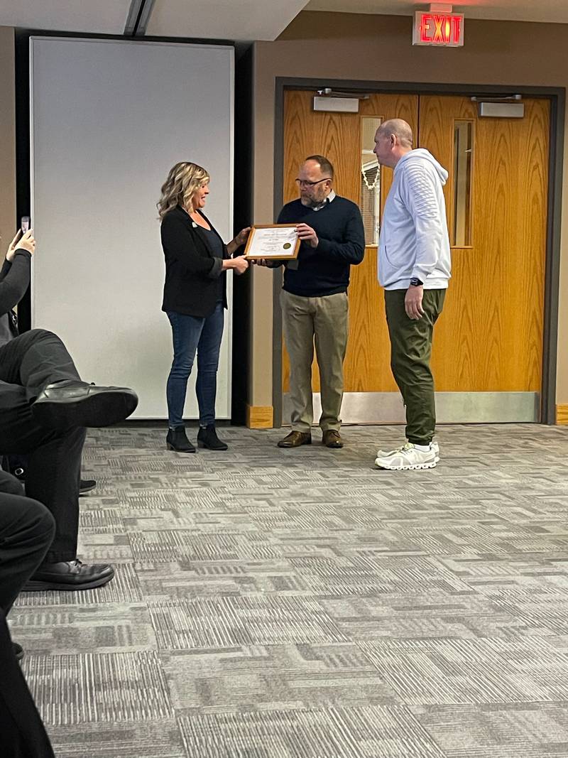 Bobbi Baehne, left, and partner Brian Rugg receive a plaque honoring 10 years in business from McHenry Mayor Wayne Jett on Friday, Jan. 26, 2024. The city has restarted its business recognition program following the pandemic.