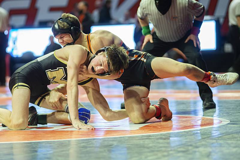 Polo's Wyatt Doty (below) works against Richland's Carson Bissey in 126lbs during the 1A third place match at the IHSA state wrestling meet on Saturday, Feb. 19, 2022.