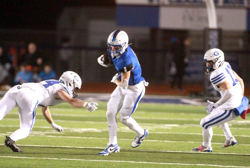 St. Charles North’s Anthony Taormina (center) runs the ball during a game against Geneva in St. Charles on Friday, Oct. 20, 2023.