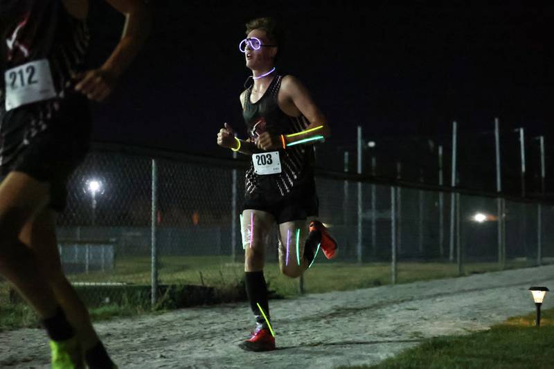 Bradley-Bourbonnais' Blake Cirar wears glow sticks during the annual night race at the All-City cross country meet at Bishop McNamara on Wednesday, Sept. 17, 2025.