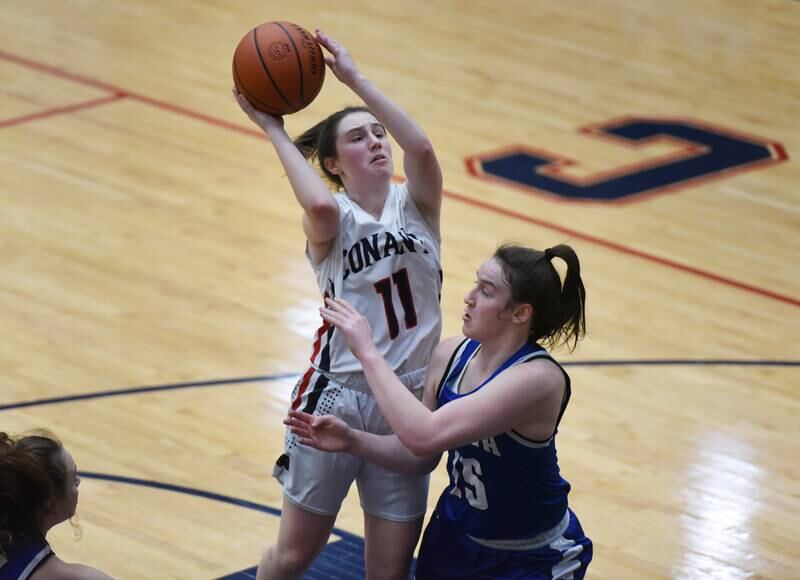 Conant's Lauren Fricke (11) is pressured under the basket by Geneva's Cassidy Arni during Friday’s IHSA Class 4A girls basketball regional championship in Hoffman Estates.