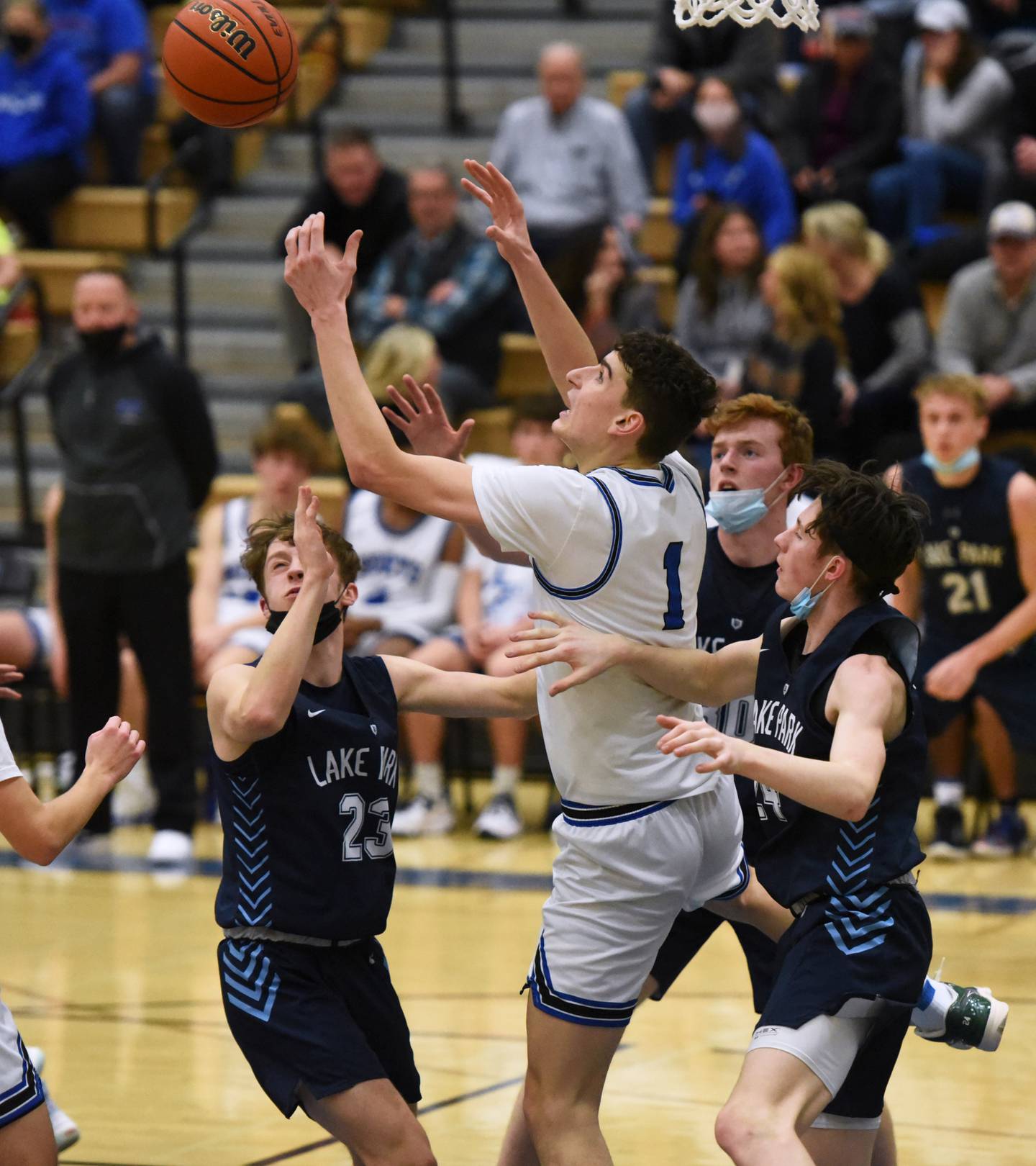St. Charles North's Ethan Marlowe (1) battles for the rebound with Lake Park's from left Matthew Zakic, Thomas Rochford and Camden Cerese during Tuesday's boys basketball game in St. Charles.