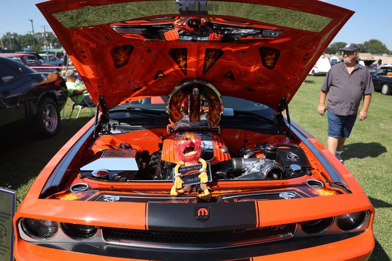 Animal, from the Muppets, is perched on the engine of a 2009 Dodge Challenger at the Crest Hill Lions Luau and Car Show on Sunday, Sept. 1, 2024 in Crest Hill.