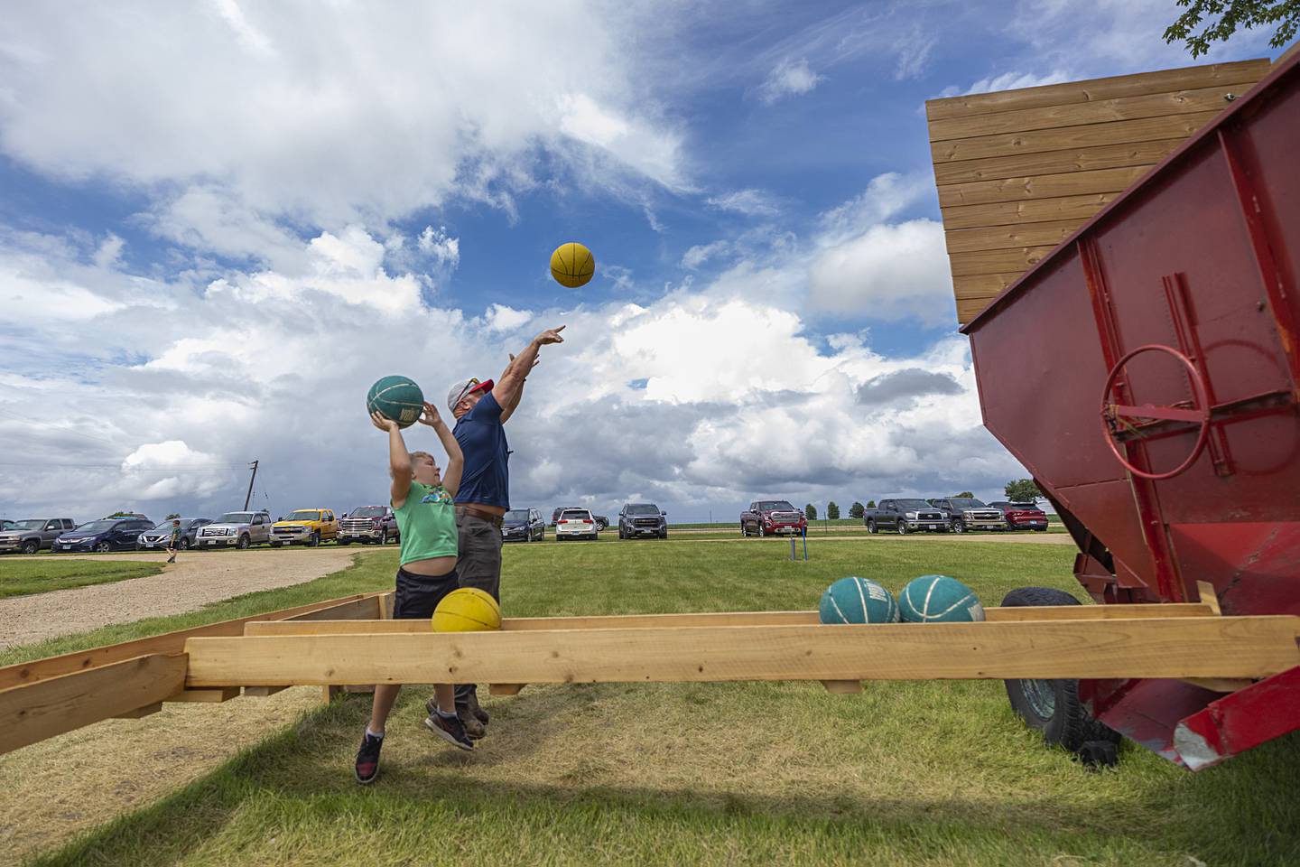 Keegan, 7, and Aaron Harrison of Amboy put up shots in a grain wagon basketball hoop Sunday, July 28, 2024, at the Lee County Fair.