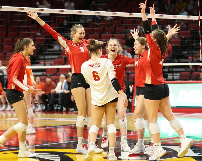 Members of the Mother McAuley volleyball team react after defeating St. Charles East in the Class 4A semifinal game on Friday, Nov. 11, 2022 at Redbird Arena in Normal.